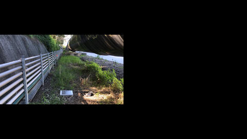 An image of a solar panel on the ground under a pipe near an embankment, landscape and inset with a black background